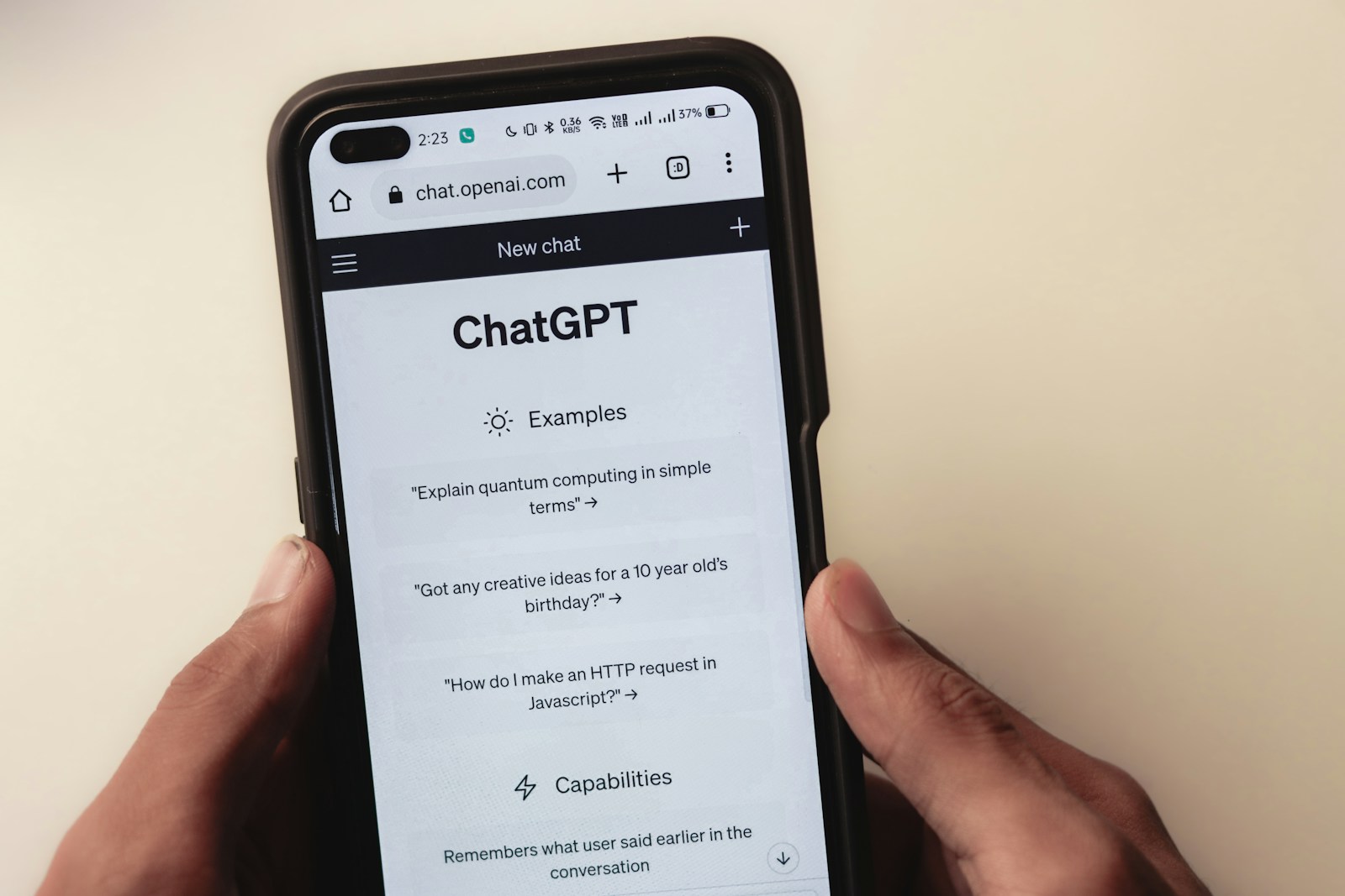 Mani che tengono smartphone con schermata di ChatGPT aperta — Shadow AI uso non autorizzato strumenti AI da parte dei dipendenti