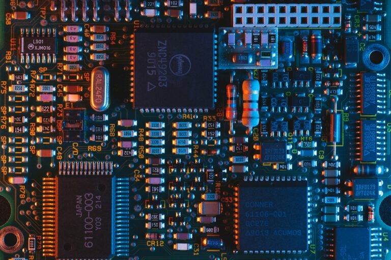 Scheda elettronica con microchip illuminati in blu e rosso — lo stack tecnologico al centro della geopolitica dell'intelligenza artificiale 2026