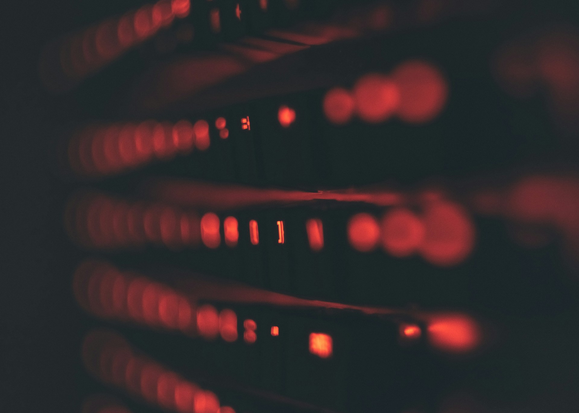 Server rack con LED rossi accesi nel buio — l